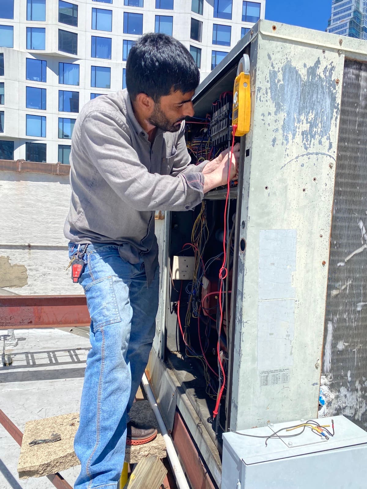 NHS technician diagnosing a rooftop HVAC system
